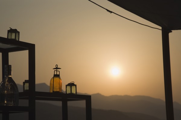 Samos, Northern Aegean, Greece. Vathy. Sun setting behind open air bar with the Ampelos massif