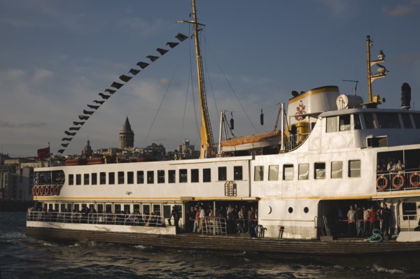 Istanbul, Turkey. Sultanahmet. Crowded ferry flying Turkish flag on the Bosphorous with city behind