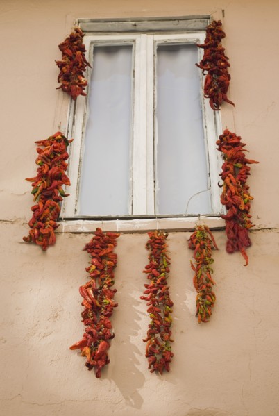 Kusadasi, Aydin Province, Turkey. Strings of red and orange chili peppers hung up to dry in summer