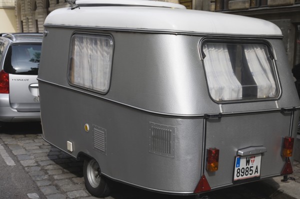 Vienna, Austria. Neubau District. Car towing vintage caravan along cobbled road. Austria Austrian