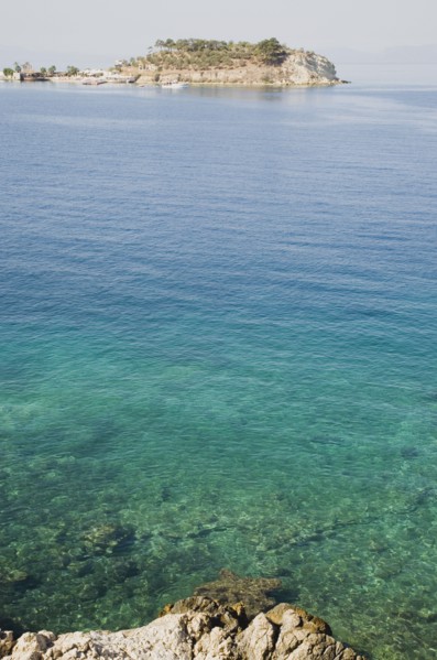 Kusadasi, Aydin Province, Turkey. View towards Guvercin Ada or Pigeon Island across clear turquoise