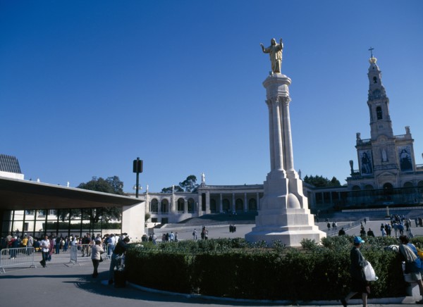 Fatima, Beira Litoral, Portugal. Golden Statue of Christ with church in background Portuguese
