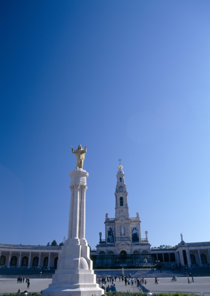 Fatima, Beira Litoral, Portugal. Golden Statue of Christ with church in background Portuguese