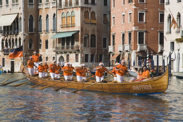 Venice, Veneto, Italy. Regatta Storico historical annual regatta. Team of rowers wearing orange and