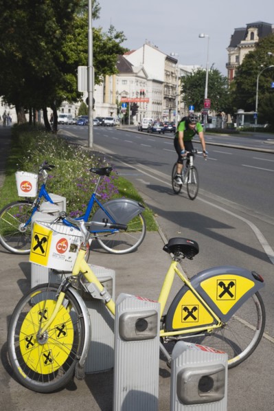 Vienna, Austria. Neubau District. Bicycles for use in city centre with approaching cyclist on road