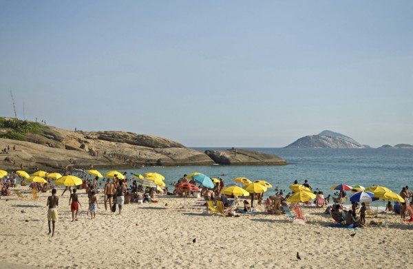 Rio de Janeiro, Brazil. Arpoador end of Ipanema beach with yellow umbrellas blue sea and sky