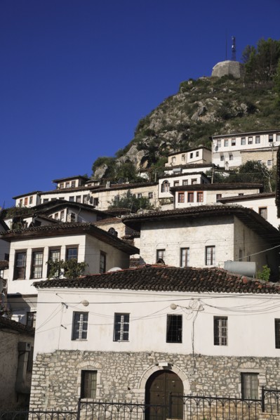 Albania, Berat, Traditional white painted Ottoman houses with tiled rooftops on hillside in the old