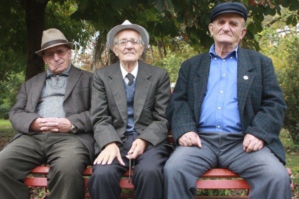 Albania, Berat, Portrait of three elderly men sitting on a park bench.