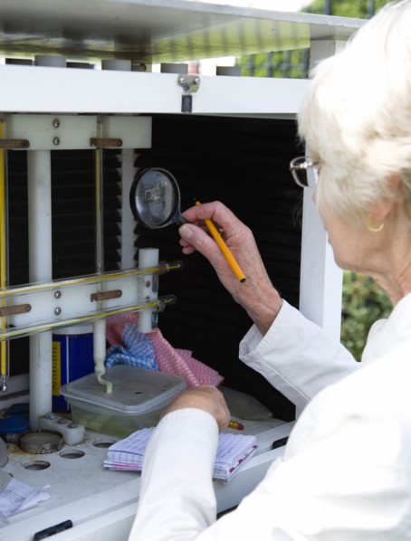 Climate, Weather, Measurements, Female weather observer using a magnifying glass to take readings