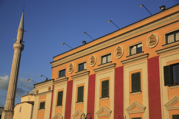Albania, Tirane, Tirana, Pink and yellow government building facades beside minaret of Ethem Bey