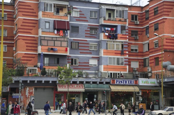Albania, Tirane, Tirana, Colourful apartment buildings with shops below.