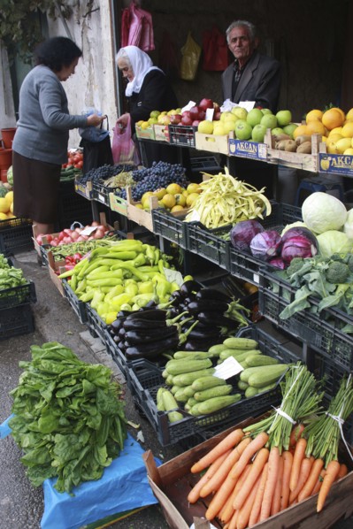 Albania, Tirane, Tirana, Customers and vendor beside display of fruit and vegetables at grocers in