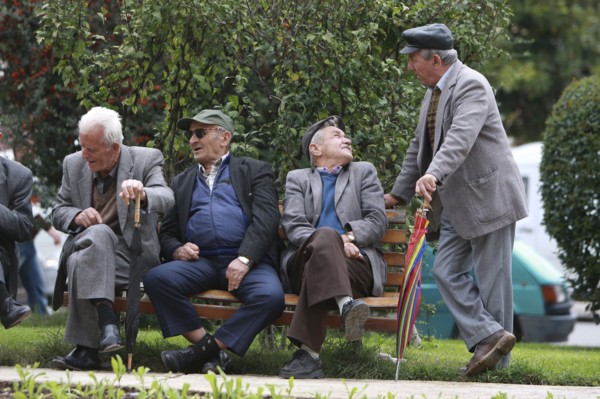 Albania, Tirane, Tirana, Group of elderly men and pensioners talking on a park bench.