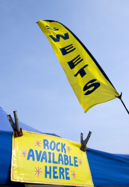 England, West Sussex, Bognor Regis, Yellow flag and sign on a tent that read Sweets and Rock