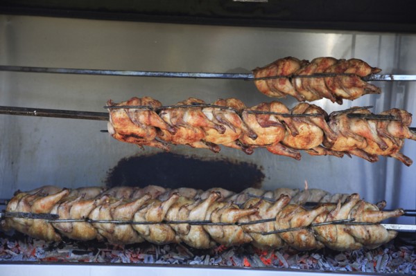 Albania, Tirane, Tirana, Spit-roasted chicken cooking over hot embers in the Avni Rustemi Market.