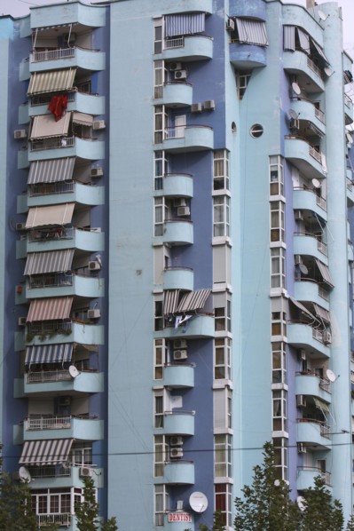 Albania, Tirane, Tirana, Balconies and striped awnings on blue painted exterior facade of multi