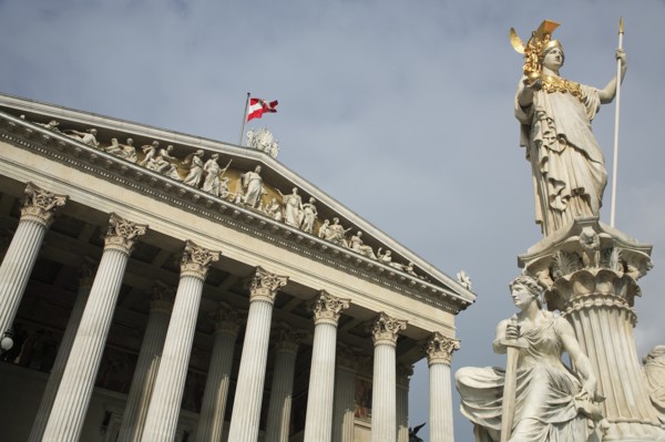 Statue of Athena raised on pillar above fountain in front of the Parliament building colonnaded