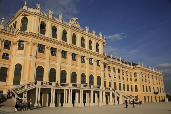 Schonnbrunn Palace. Part view of exterior facade with tourist visitors on flight of steps and in