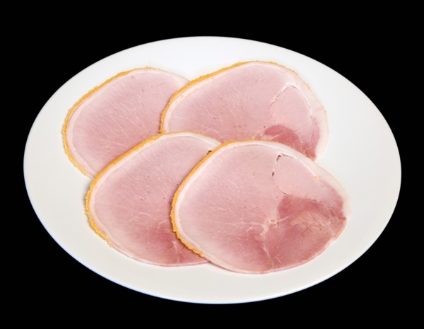 Slices of cured ham on a round white plate on a black background. Photo: Paul Seheult