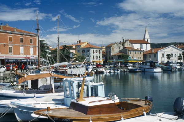 Port with fishing boats. People walking past shops and restaurants. Photo : Jonas Grau