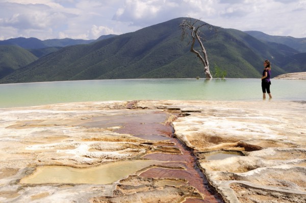 Mexico, Oaxaca, Hierve el Agua, Female tourist standing in limestone pool with view towards