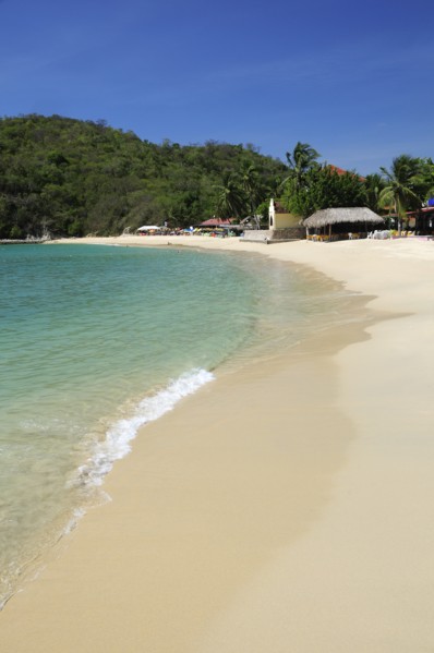 Mexico, Oaxaca, Huatulco, Bahia Santa Cruz View along stretch of sandy beach lined by restaurants