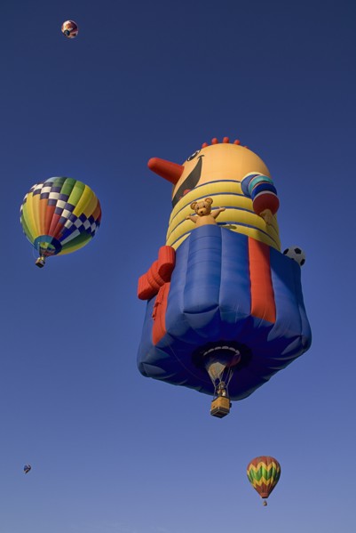 USA, New Mexico, Albuquerque, Annual balloon fiesta colourful hot air balloons ascending. 
Photo :