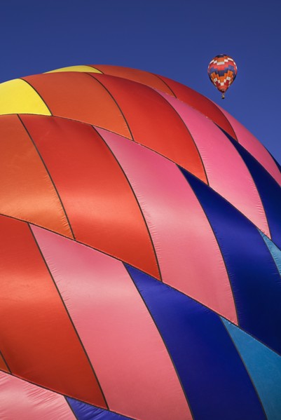 USA, New Mexico, Albuquerque, Annual balloon fiesta colourful hot air balloons with part view of