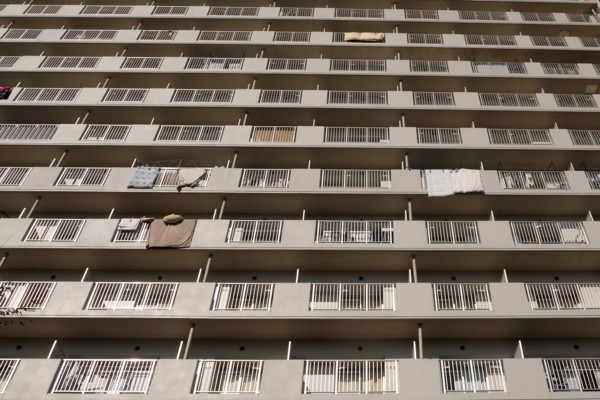 Japan, Honshu, Tokyo, Exterior or an apartment block with futon mattresses hung over balcony rails