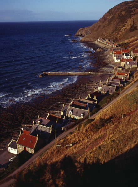 Scotland, Aberdeenshire, Crovie, One time fishing village seen from cliff top. Row of cottages at