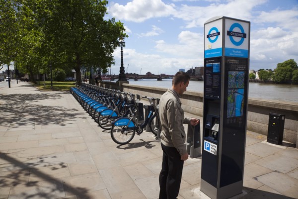 England, London, Vauxhall Albert Embankment of the river Thames man buying time on bicycle hire