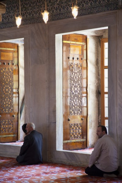 Turkey, Istanbul, Sultanahmet Camii Blue Mosque interior with men at worship. 
Photo : Stephen