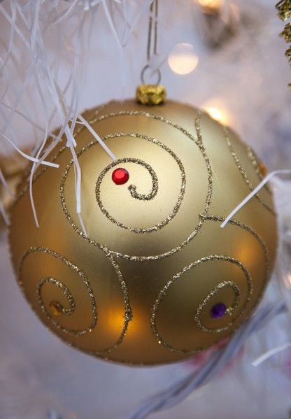 Festivals, Christmas, Decorations gold coloured bauble with white tinsel and fairy lights. 
Photo