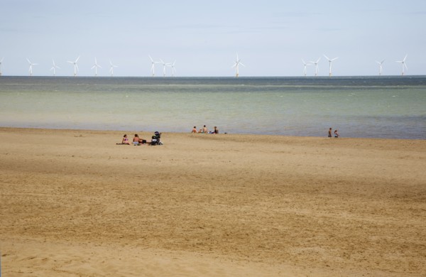 Wind Farm offshore on the horizon showing turbine blades.
