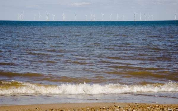 Wind Farm offshore on the horizon showing turbine blades.