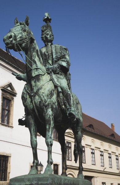 Buda Castle District: Bronze statue of mounted Hussar on street of restored facades.