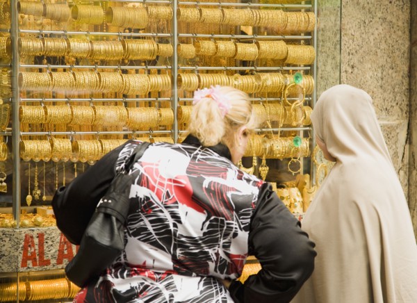 Women one veiled shop for gold jewellery in window display of Gold Souk Deira.