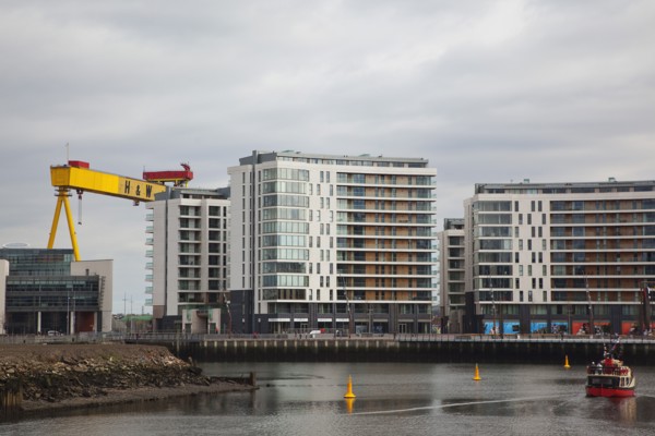 Titanic Quarter Modern apartment blocks on the site of the Harland & Wolff shipyard with sightseeing cruise boat.
