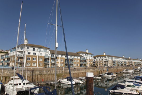 View over boats moored in the Marina with apartment buildings behind.