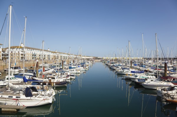 View over boats moored in the Marina with apartment buildings behind.