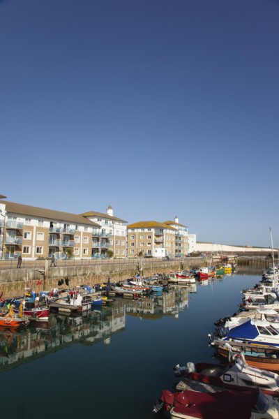 View over boats moored in the Marina with apartment buildings behind.
