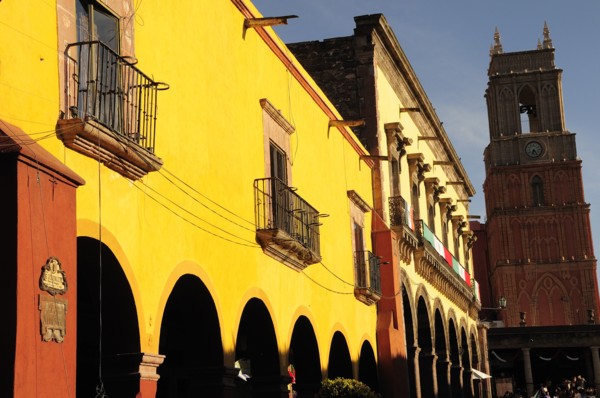 Mexico, Bajio, San Miguel de Allende, El Jardin Yellow facade of colonial mansion and arcades with