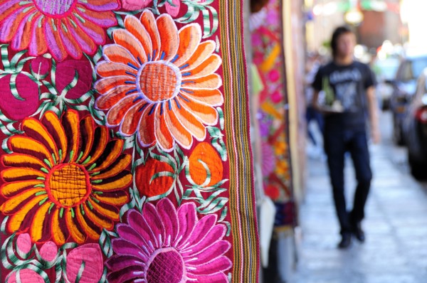 Mexico, Bajio, San Miguel de Allende, Brightly coloured embroidered textile hanging outside arts