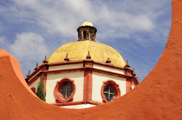 Mexico, Bajio, San Miguel de Allende, Dome of the Parroquia church part framed by orange painted