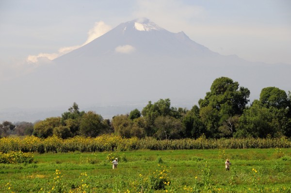 Mexico, Puebla, Popocatepetl, View towards volcanic cone of Popocatepetl with figures working in