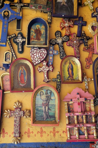 Mexico, Michoacan, Patzcuaro, Religious kitsch art displayed on yellow painted wall. Photo : Nick