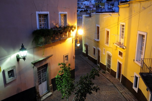 Mexico, Bajio, Guanajuato, Elevated view over street corner at night with painted building facades