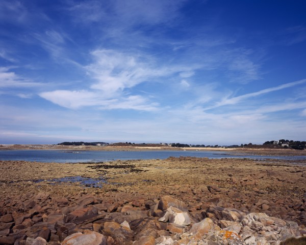 France, Cotes d Amor, Brittany, Cote de Granit Rose. Rocky shoreline with view towards Ile Grand on