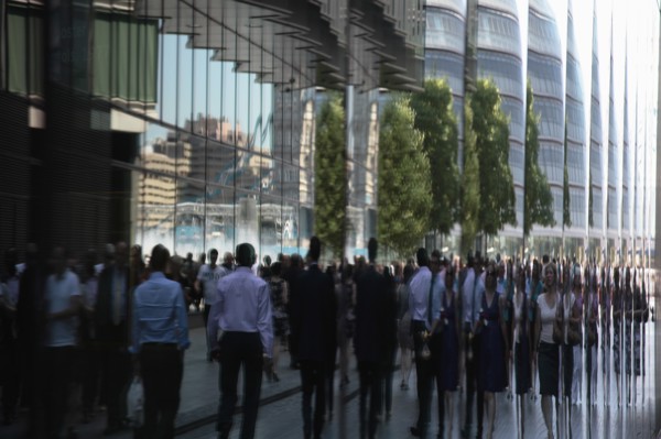 England, London, Southwark Office workers reflected in glass building next to City Hall. Photo :