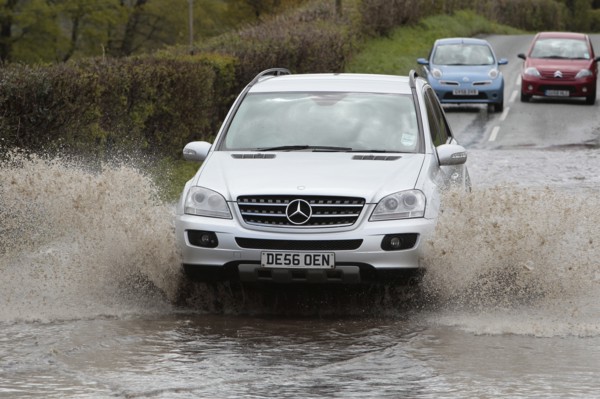 England, Kent, Flooding, Flooded country road with cars driving slowly through waters. Photo : Sean